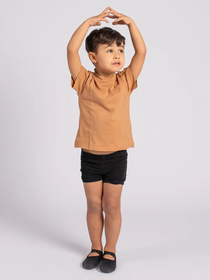 Niño en clase de ballet infantil en Madrid, en posición con los brazos en corona