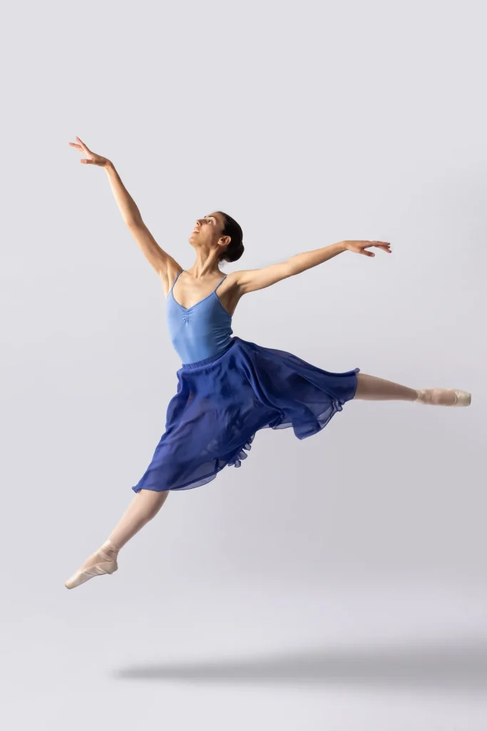 Bailarina de CDAM en grand jeté con vestido azul, sesión artística de estudio