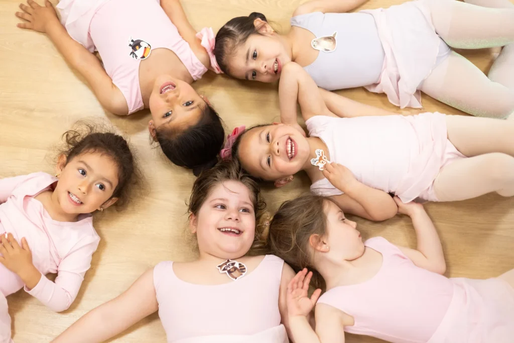 Alumnas de pre ballet sonriendo en círculo durante una clase en CDAM Madrid