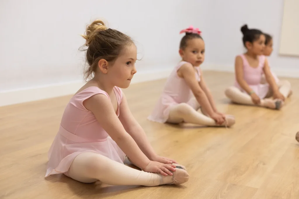 Alumna estirando con concentración en una clase de ballet infantil de CDAM