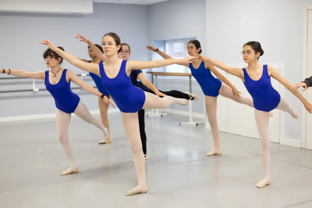 Alumnas de Grado 5 en arabesque durante la clase de ballet en CDAM