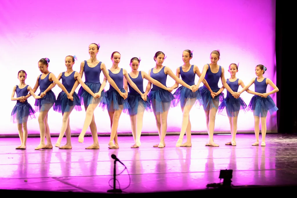 Fila de alumnas con tutú azul cogidas de la mano en el Festival de Fin de Curso de CDAM