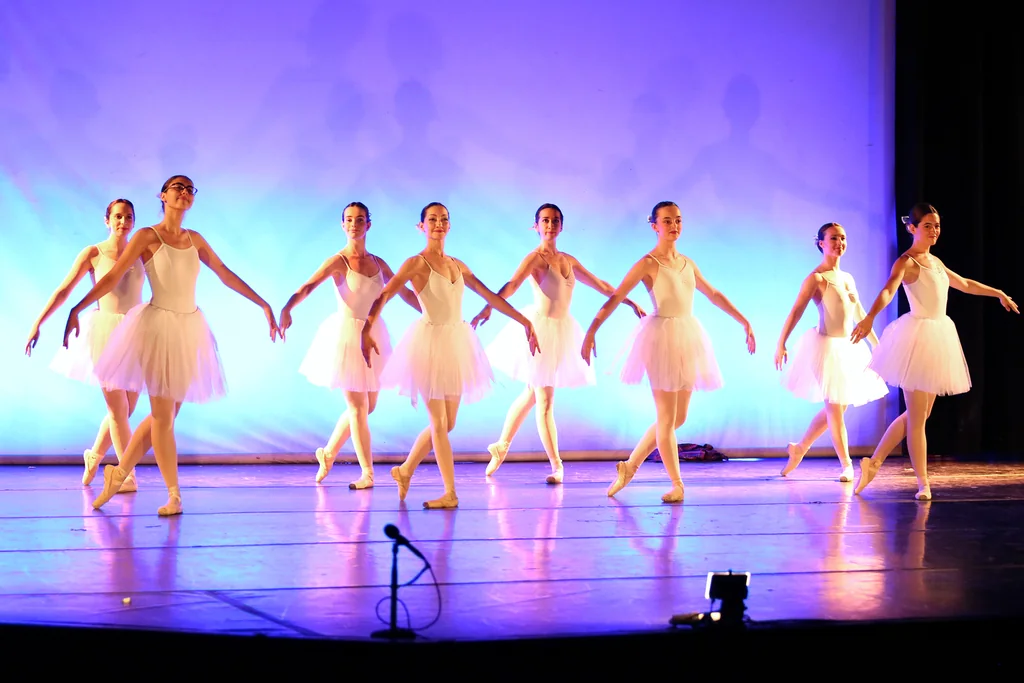 Fila de alumnas con tutú blanco sobre fondo lila en el Festival de Fin de Curso de CDAM