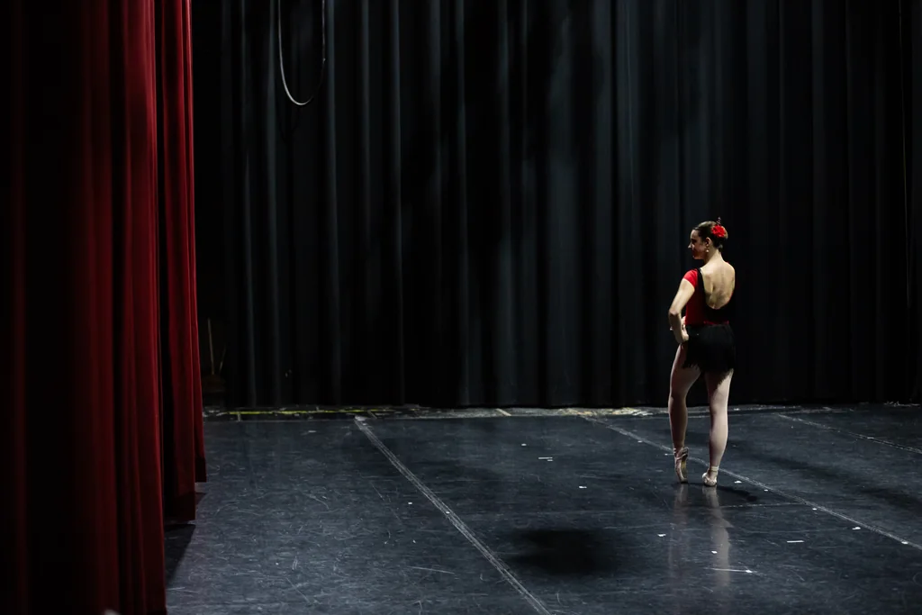 Bailarina con traje rojo y negro esperando su entrada en el escenario en la Gala Española de CDAM