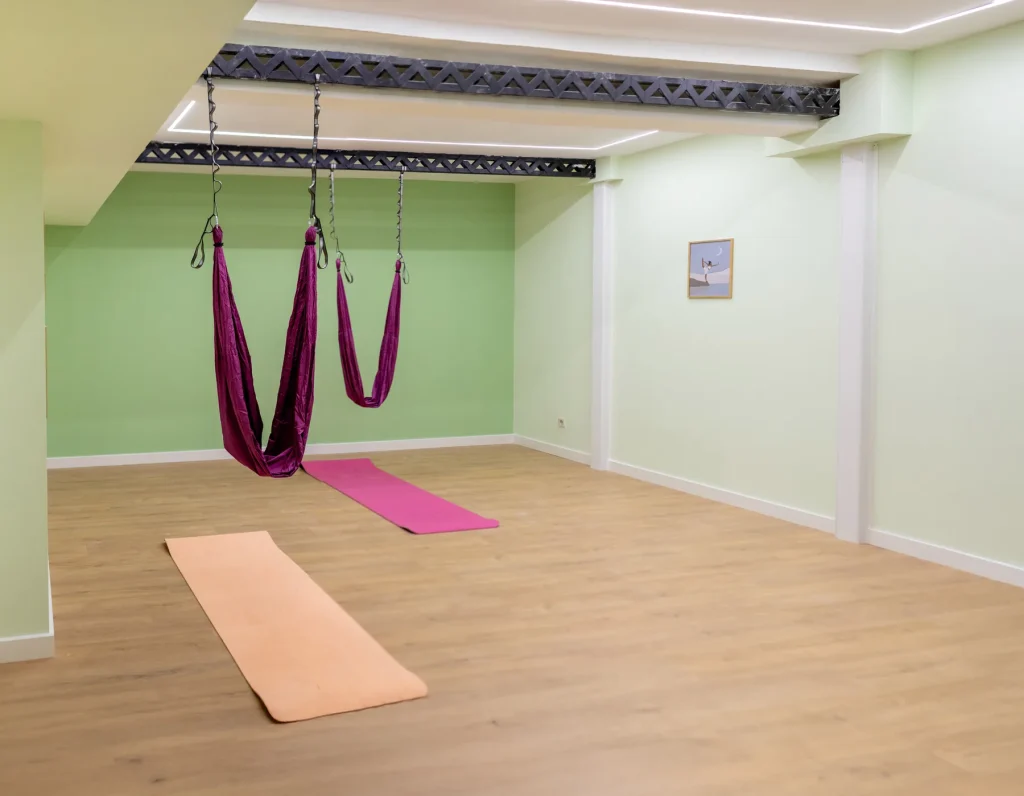 Sala del CDAM con columpios de suspensión, esterillas y suelo de madera